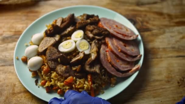 Coloquei o pilaf uzbeque no prato. Decore bem com carne cortada. 4k vídeo — Vídeo de Stock