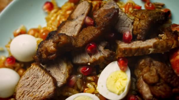 Goûtez à la cuisine ouzbèke Mariage émouvant Pilaf. Il est joliment décoré avec des œufs et des saucisses. Vidéo 4k — Video