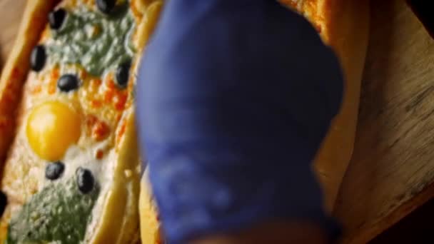 Tillsätt ruccola till salamipiden. Vegetarisk pidbrygga med ägg och pir med salami. 4k-video — Stockvideo