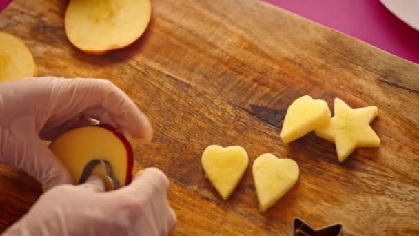 Aku memotong potongan apel dalam bentuk hati dan bintang-bintang. Video 4k — Stok Video