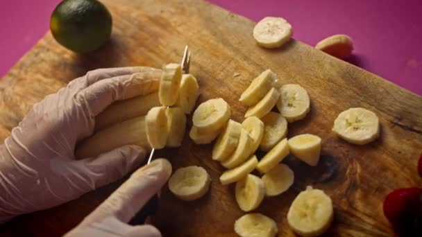 Pokroić banany na kawałki. 4k wideo — Wideo stockowe