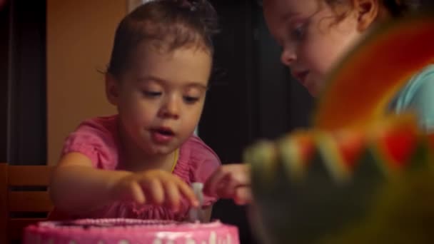 Gelukkig meisje viert haar verjaardag met familie die de kaarsen op haar taart uitblaast. Ouders en grootouders kijken naar het kleine kind dat cake kaarsen uitblaast — Stockvideo