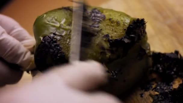 Queime com a faca o filme queimado da pimenta verde. Eu preparo pimentas mexicanas recheadas com molho de noz. 4k vídeo — Vídeo de Stock