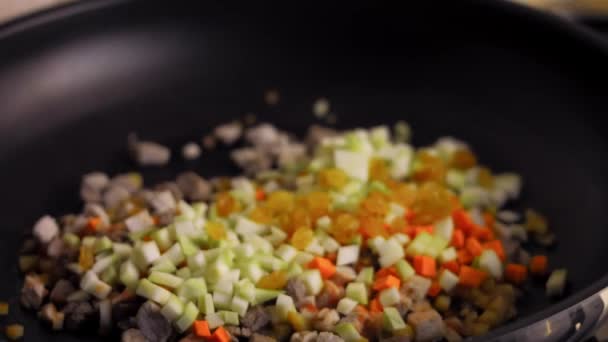 Προσθέτουμε σταφίδες στο μείγμα του τηγανίσματος. Ετοιμάζω μεξικάνικα Poblano Peppers σε σάλτσα καρυδιών. Βίντεο 4k — Αρχείο Βίντεο