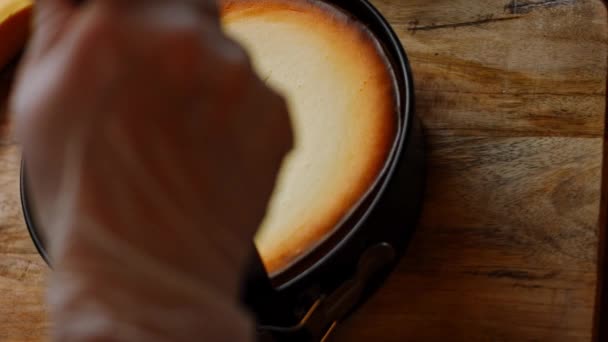 Corte a borda do cheesekake com uma faca para que ele nãogrude. 4k vídeo — Vídeo de Stock
