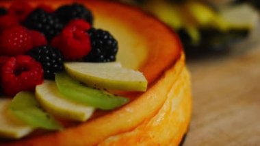 Cheesekake 'in üzerine elma ve kivi dilimleri koy. 4k video