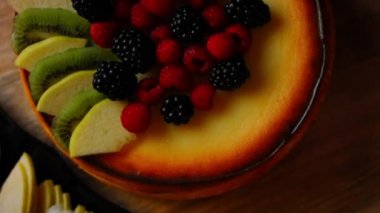 Cheesekake 'in üzerine elma ve kivi dilimleri koy. 4k video