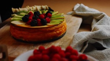 Cheesekake 'in üzerine elma ve kivi dilimleri koy. 4k video