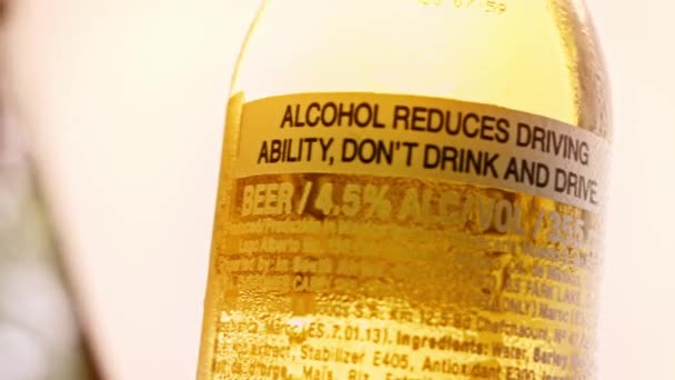 Cerveza fría con inscripción. Es peligroso beber alcohol. 4k video casero — Vídeos de Stock