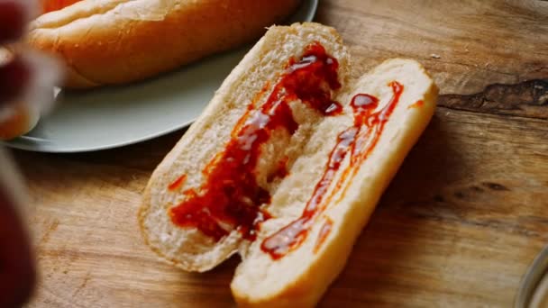 Ich lege die BBQ Bruts Sauce über das Hot Dog Brot. 4k hausgemachtes Video — Stockvideo