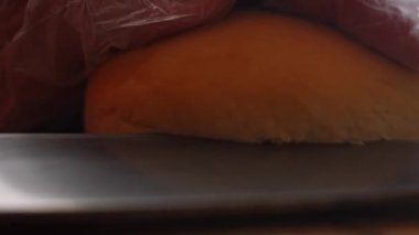Hamburger için ekmeği kes. Klasik Amerikan hamburgerinin tadına bak. 4k video