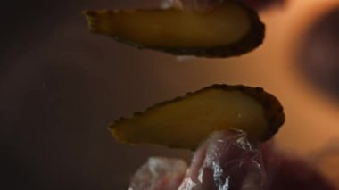 Hamburgerin içine doğranmış turşu koydum. Camın altından çekiyoruz. Klasik Amerikan hamburgerinin tadına bak. 4k video