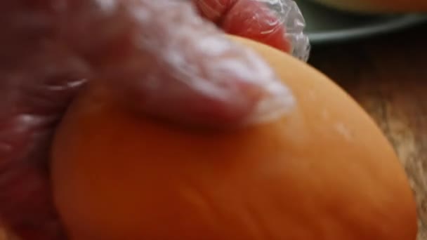 Corta o pão para o hambúrguer. Gosto de hambúrguer americano clássico. 4k vídeo — Vídeo de Stock