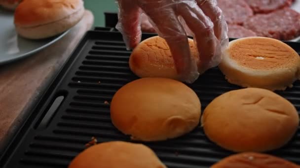 Friggere il pane hamburger sulla griglia. Gusto classico hamburger americano. 4k video — Video Stock