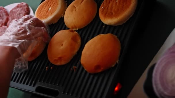 Freír el pan de hamburguesa en la parrilla. Prueba la clásica hamburguesa americana. Vídeo 4k — Vídeo de stock