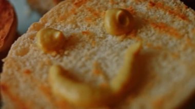 Klasik Amerikan hamburgerinin tadına bak. Hamburger ekmeğinin üzerinde mutlu bir hardal gülümsemesi. 4k video