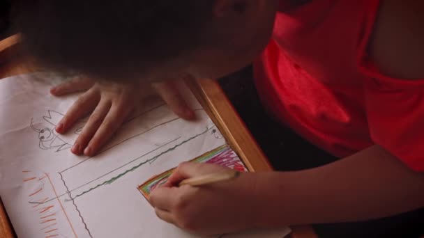 A menina desenha no papel e gosta. Educação de mesa. 4k vídeo — Vídeo de Stock