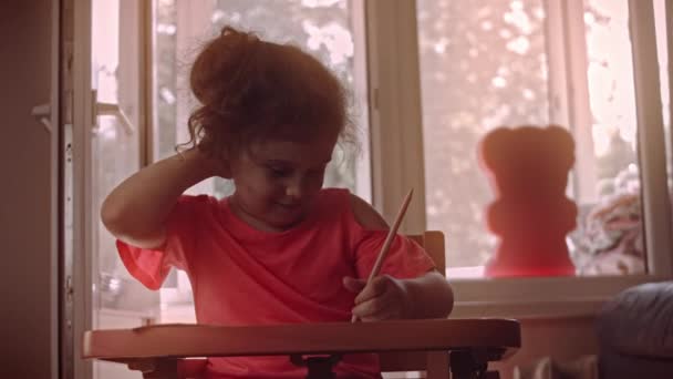 소녀는 종이에 그림을 그리며 즐긴다. 테이블 교육. 4k 비디오 — 비디오
