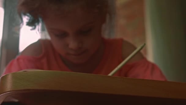Dziewczyna rysuje na papierze i cieszy się. Edukacja stołowa. 4k wideo — Wideo stockowe