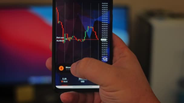 Téléphone sur Bitcoin Crypto devise Or Bitcoin BTC Bit Coin gros plan de Bitcoin pièces sur fond noir. écran de téléphone marchés boursiers graphique dynamique à la hausse. Vidéo macro 4k — Video