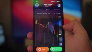 Bitcoin Kripto para birimi Altın Bitcoin BTC Bit Bozukluğu üzerindeki telefon siyah arka planda Bitcoin paralarını kapatın. Telefon ekranı borsaları dinamik şemayı yükseltiyor. 4k makro video