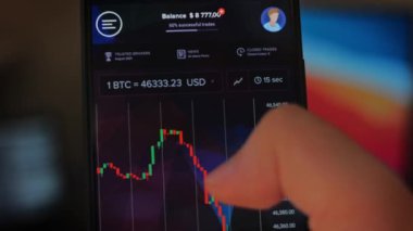 Bitcoin Kripto para birimi Altın Bitcoin BTC Bit Bozukluğu üzerindeki telefon siyah arka planda Bitcoin paralarını kapatın. Telefon ekranı borsaları dinamik şemayı yükseltiyor. 4k makro video