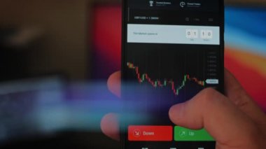 Bitcoin Kripto para birimi Altın Bitcoin BTC Bit Bozukluğu üzerindeki telefon siyah arka planda Bitcoin paralarını kapatın. Telefon ekranı borsaları dinamik şemayı yükseltiyor. 4k makro video