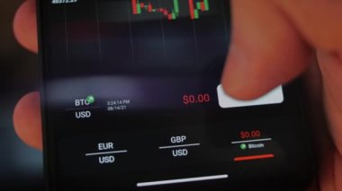 Bitcoin Kripto para birimi Altın Bitcoin BTC Bit Bozukluğu üzerindeki telefon siyah arka planda Bitcoin paralarını kapatın. Telefon ekranı borsaları dinamik şemayı yükseltiyor. 4k makro video