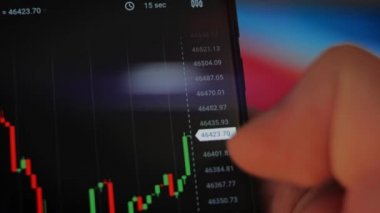 Bitcoin Kripto para birimi Altın Bitcoin BTC Bit Bozukluğu üzerindeki telefon siyah arka planda Bitcoin paralarını kapatın. Telefon ekranı borsaları dinamik şemayı yükseltiyor. 4k makro video