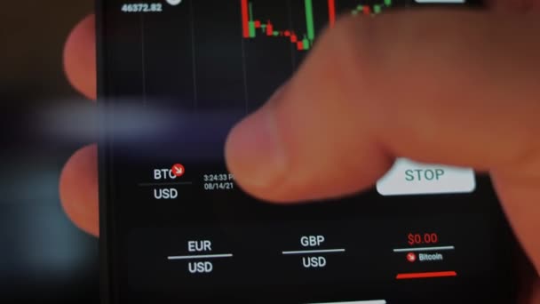 Téléphone sur Bitcoin Crypto devise Or Bitcoin BTC Bit Coin gros plan de Bitcoin pièces sur fond noir. écran de téléphone marchés boursiers graphique dynamique à la hausse. Vidéo macro 4k — Video