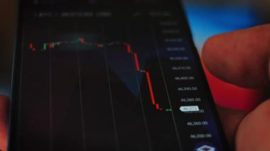 Bitcoin Kripto para birimi Altın Bitcoin BTC Bit Bozukluğu üzerindeki telefon siyah arka planda Bitcoin paralarını kapatın. Telefon ekranı borsaları dinamik şemayı yükseltiyor. 4k makro video
