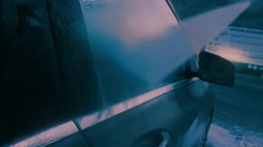 Adam çamaşırhanede arabayı yıkar. Gece çekimi