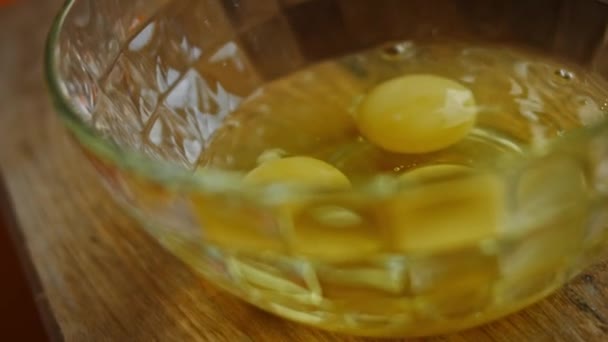 Rompo los huevos en un tazón transparente. Vídeo 4k — Vídeo de stock