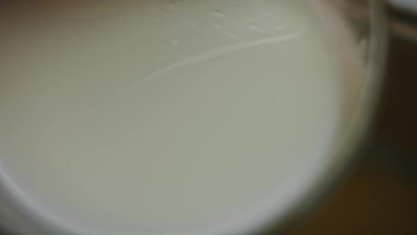 Vierta un vaso de leche sobre los ingredientes del helado y mezcle. Vídeo 4k — Vídeo de stock