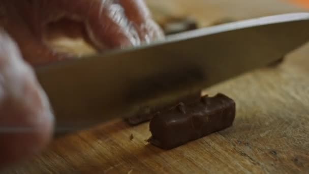 Corte snickers em pequenos pedaços e adicione à tigela de sorvete. 4k vídeo — Vídeo de Stock