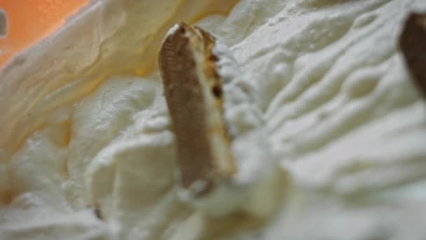 Вырезать сникеры на мелкие кусочки и добавить в миску мороженого. 4k видео — стоковое видео