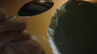 Genç bayan bir kaşıkla dondurma yiyor. Alt 4k makro camı delip geçiyor.