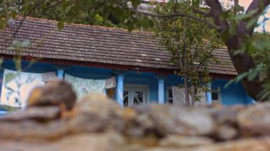 Tepedeki eski Balkan ulusal evi. Elbiseleri iple kurutuyorum. 4k video