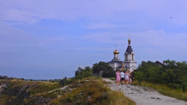 Les touristes gravissent la colline jusqu'à l'église. Église orthodoxe 4k vidéo — Video
