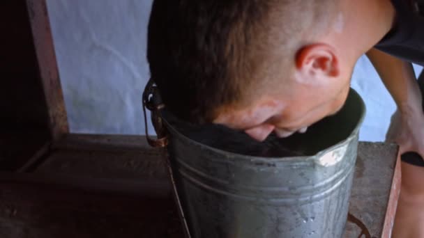 O viajante bebe água da caldeira no campo bem. 4k vídeo — Vídeo de Stock