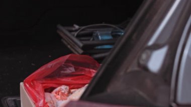 İşçi donmuş et kutusunu arabanın bagajına koyar. 4k video