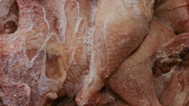 Vista de cerca de las manos en guantes que empaquetan las patas de pollo de una caja en bolsas de plástico individuales. Proceso de congelación de la carne para su uso posterior en el hogar. 4k video con juego de luz — Vídeos de Stock