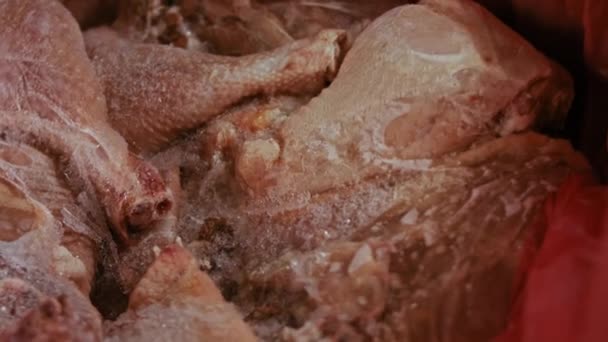 Close-up view of hands in gloves packing chicken legs from a box into individual plastic bags. Process of freezing meat for further use at home. 4k video with light play — Stock Video