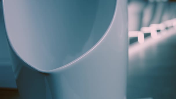 Draaiende urinoirs. Studio filmen. Op de achtergrond een rij toiletten. 4k video — Stockvideo