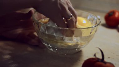 Yakın plan kadın eli, hamur malzemelerini cam kasede karıştırıyor..