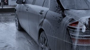 Tamamen köpükle kaplı lüks bir arabanın araba yıkama işlemi..