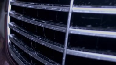 Su, yüksek basınç altında bir oto yıkama yerindeki radyatör ızgarasında akar..