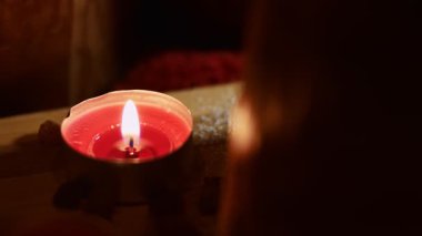 Tatil yemeği süsü olarak yanan kırmızı mum, kapat..