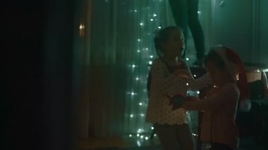 Noel tatili için evlerini dekore eden aile, süslemelerle oynayan çocuklar..