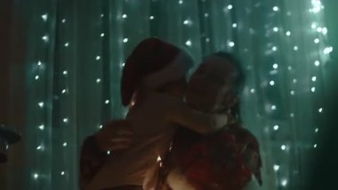 Noel tatili için evlerini dekore eden aile, Noel Baba şapkası takan mutlu kızlar annelerine sarılıyorlar..